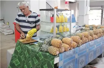  ?? Photo: Susana Tuilau ?? Brij Lal cutting a pineapple at the new Rakiraki Market.