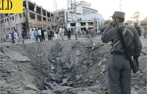  ?? RAHMAT GUL / THE ASSOCIATED PRESS ?? Security forces stand next to a crater created by a massive explosion in front of the German Embassy in Kabul, Afghanista­n, on Wednesday.