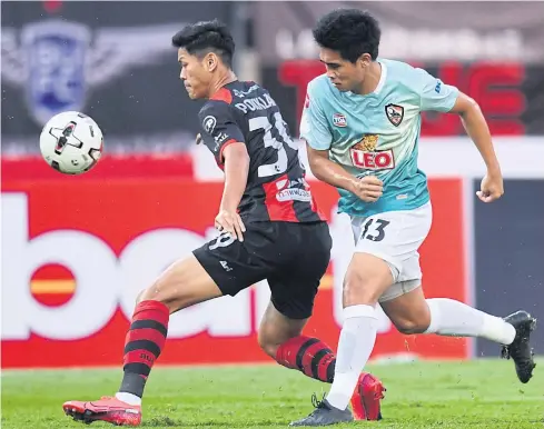  ??  ?? Bangkok United’s Pokklaw A-Nan, left, in action against Chiang Rai United’s Chotipat Poomkeaw last night.