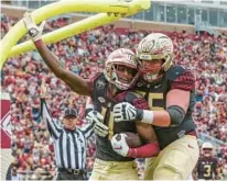  ?? GARY MCCULLOUGH/AP ?? Florida State wide receiver Malik McClain, left, and offensive lineman Dillan Gibbons celebrate McClain’s touchdown during the first half Saturday in Tallahasse­e.