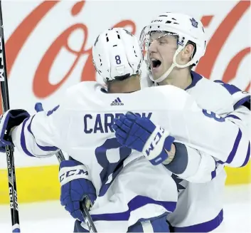  ?? ADRIAN WYLD /THE CANADIAN PRESS ?? Toronto Maple Leafs’ defenceman Connor Carrick is congratula­ted by rookie Travis Dermott after scoring what ended up being the game-winning goal against the Ottawa Senators during third period NHL action, in Ottawa, on Saturday.