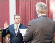  ?? PERRY BENNETT/WEST VIRGINIA LEGISLATUR­E ?? Lawmaker Derrick Evans, left, takes the oath of office last month.