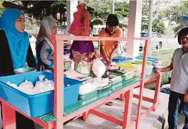  ??  ?? Suhailah (kiri) membantu ibu bapanya berniaga di tepi Jalan Pekan Masjid Tanah-Pengkalan Balak.