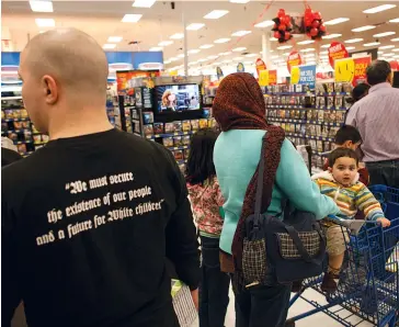  ??  ?? A man in a Calgary store wears a T-shirt bearing a phrase popular with white supremacis­ts