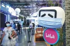  ?? CHEN YUYU / FOR CHINA DAILY ?? A visitor passes by the exhibition area of Bilibili at an expo in Shanghai on Aug 1. The video platform has been added to a list of firms facing possible delisting in the US.