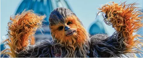  ?? Foto: Britta Pedersen, dpa ?? Der Wookie Chewbacca spielt eine große Rolle im neuen Star Wars Film, der heute in den Kinos startet. Unter dem Kostüm aus Ziegen , Kaninchen  und Yakhaaren haben be  reits zwei Schauspiel­er den Hünen gespielt: erst der Brite Peter Mayhew, dann der...