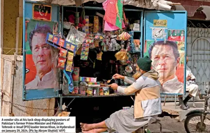  ?? ?? A vendor sits at his tuck shop displaying posters of Pakistan's former Prime Minister and Pakistan Tehreek-e-Insaf (PTI) leader Imran Khan, in Hyderabad on January 29, 2024. (Pic by Akram Shahid/ AFP)