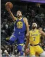  ?? JOHN LOCHER — THE ASSOCIATED PRESS FILE ?? In this file photo, Golden State Warriors guard Stephen Curry shoots next to Los Angeles Lakers center JaVale McGee during the second half of an NBA preseason basketball game, in Las Vegas.