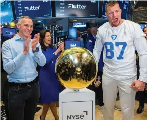  ?? ?? Betting on the US: Flutter chief Peter Jackson and ex-American football star Rob Gronkowski ring the opening bell on the floor of the New York Stock Exchange