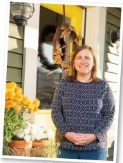  ?? ?? Decked in cheerful pastels and bountiful fall florals, Heather’s front porch is a reflection of the warm cottage ambience behind the bright yellow door.