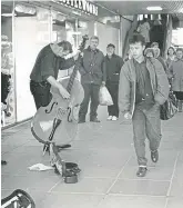  ?? ?? A busker beside Littlewood­s in 1990.