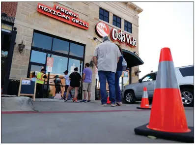  ?? (AP/Tony Gutierrez) ?? Cones serve as markers to help customers keep their distance from one another Monday outside Costa Vida, a Mexican restaurant in Colleyvill­e, Texas.