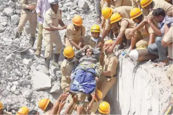  ?? — AFP ?? Rescuers carry a survivor recovered from the rubble of an under-constructi­on building that collapsed.