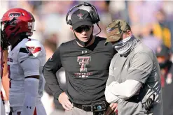  ?? AP Photo/Charlie Riedel ?? ■ Kansas State coach Chris Klieman, right, and Texas Tech coach Matt Wells talk during a timeout for an injury during the second half of an NCAA college football game Saturday in Manhattan, Kan.