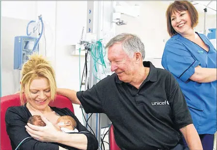  ??  ?? AMBASSADOR: Sir Alex Ferguson chats to a young mother with twin newborn babies after calling in for a visit at Southern General Hospital in Glasgow.