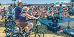  ?? PAT EATON-ROBB/AP ?? Madi Diaz, right, performs on the Newport Folk Festival’s “Bike Stage,” powered in part by festivalgo­ers on stationary bicycles.