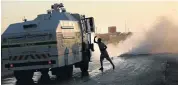  ?? Picture: ALON SKUY ?? ANGER: A protester strikes a police vehicle as it extinguish­es a fire at Hammanskra­al, north of Pretoria