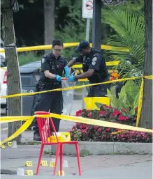  ?? TYLER ANDERSON / NATIONAL POST ?? Police officers bag evidence at the scene where a gunman shot more than a dozen people on Danforth Avenue in Toronto on Sunday night.
