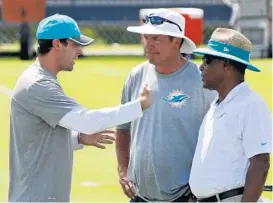  ?? WILFREDO LEE/ASSOCIATED PRESS ?? Adam Gase, left, talks with Miami legend Dan Marino, center, and Nat Moore, senior vice president of special projects and alumni relations, during last month’s minicamp in Davie.