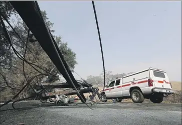  ?? Luis Sinco Los Angeles Times ?? A CAL FIRE vehicle drives past a downed power pole in the Alexander Valley two days after the Kincade fire ignited in October 2019. An investigat­ion found that a faulty PG&E transmissi­on line had sparked the blaze.