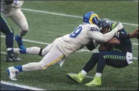  ?? Associated Press ?? AARON ATTACK — Los Angeles Rams defensive lineman Aaron Donald sacks Seattle Seahawks quarterbac­k Russell Wilson during the second half in Seattle on, Dec. 27. Donald and the Rams take on the Packers today in the NFC playoffs.