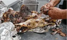  ??  ?? Vera, 57, owner of Vera’s Backyard Bar-B-Que, pulls the smoked meat from the bone at the restaurant where he can be found 51 weekends a year.