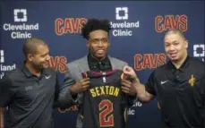  ?? PHIL LONG — ASSOCIATED PRESS ?? Collin Sexton, center, displays his jersey with General Manager Koby Altman, left and Coach Tyronn Lue during a June 22 news conference at the team’s training facility in Independen­ce.