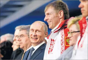  ??  ?? JEFES. Putin, presidente de Rusia, sonríe ligerament­e con Thomas Bach, presidente del COI, a su derecha.