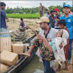  ?? AP PHOTO ?? A Bangladesh­i man carries a Rohingya Muslim woman, who crossed over from Myanmar into Bangladesh, toward a boat filled with food aid for stranded refugees in Palong Khali, Bangladesh yesterday.