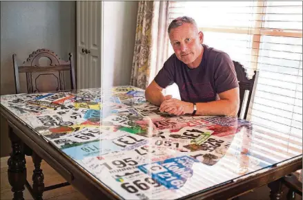  ?? TOM MCCARTHY JR. FOR AMERICAN-STATESMAN ?? Avid Austin runner Kent Kohler uses an antique table that once belonged to his grandmothe­r as a display case for all of his race bibs and medals, placing them beneath glass on the kitchen tabletop. The display contains tokens from his most meaningful...