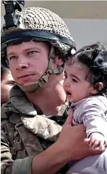  ??  ?? Rescuer: Soldier cradling a baby