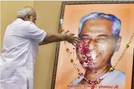  ?? — PTI ?? Prime Minister Narendra Modi pays floral tributes at the portrait of Laxman Rao Inamdar during his birth centenary celebratio­n and Sahakar Sammelan in New Delhi on Thursday.