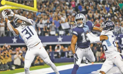  ?? PHOTOS BY MICHAEL AINSWORTH/ASSOCIATED PRESS ?? Titans free safety Kevin Byard, left, intercepts a pass intended for Cowboys wide receiver Amari Cooper, center, during Monday’s game in Arlington, Texas. Tennessee won 28-14.