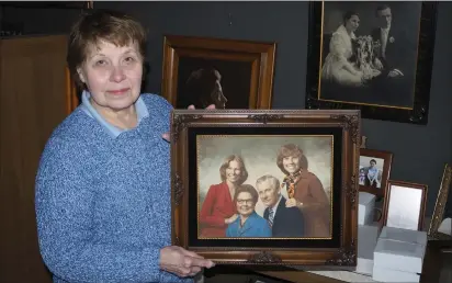  ?? Photo by Joseph B. Nadeau ?? Beauchemin holds a photograph of her family, one of several still on the walls of the family’s former Tenczar Studios business at Park Square.