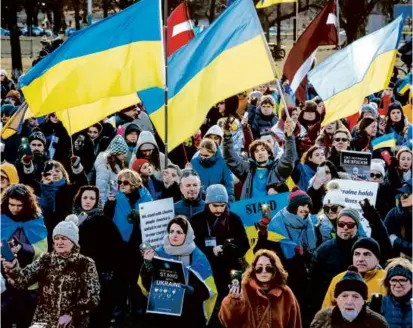  ?? ERIN CLARK/GLOBE STAFF ?? Many of those gathered at the Parkman Bandstand Saturday waved Ukrainian flags and held signs in support of the country.