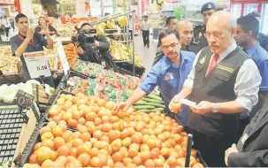  ?? — Gambar Bernama ?? PANTAU: Mohd Roslan (kanan) melihat harga barang kawalan ketika membuat tinjauan kawalan harga musim perayaan Krismas dan jualan murah di AEON Cheras Selatan di Kuala Lumpur, semalam. Turut hadir Timbalan Pengarah Pencegahan, Perisikan Bahagian...