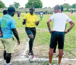  ??  ?? Referee Garnett Page (centre) in discussion with Norman Manley High School head coach Shane Gage (left) and his St George’s College counterpar­t Neville Bell before deciding to call off their ISSA/Digicel Manning Cup game at Maxfield Park yesterday because of lightning in the area.