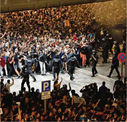  ?? (PAU BARRENA/AFP) ?? Policiers entourés de manifestan­ts indépendan­tistes lundi à l’aéroport de Barcelone.