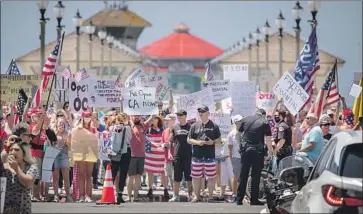  ?? Allen J. Schaben Los Angeles Times ?? THOUSANDS OF protesters rally at the intersecti­on of Main Street and Pacific Coast Highway in Huntington Beach in May to call on Gov. Newsom to reopen the beaches and relax the state's stay-at-home order.