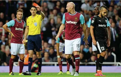  ?? BPI ?? Deja vu: James Collins (No 19) is sent off by referee Adrien Jaccottet as West Ham’s night unravels