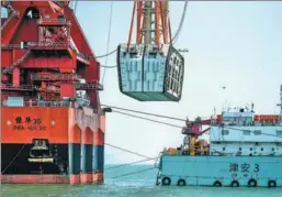  ?? CHEN JIMIN / CHINA NEWS SERVICE ?? TheZhenhua 30 crane ship (left) hoists the final section of the underwater tunnel for the Hong Kong-Zhuhai-Macao bridge to its designated location on Tuesday.