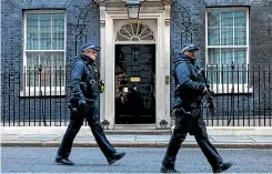  ?? GETTY IMAGES ?? Police officers patrol outside 10 Downing Street in London, England.