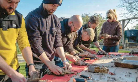  ?? ANDREW TESTA/THE NEW YORK TIMES 2022 ?? People butcher partridge and pheasant during a culinary class Nov. 12 at Firle Estate in Sussex, England.