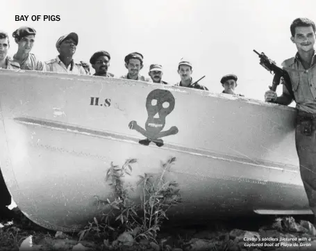  ??  ?? Castro’s soldiers pictured with a captured boat at Playa de Giron