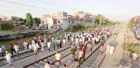  ?? — Reuters ?? People gather at the site of an accident after a commuter train travelling at high speed ran through a crowd of people on the rail tracks in Amritsar.