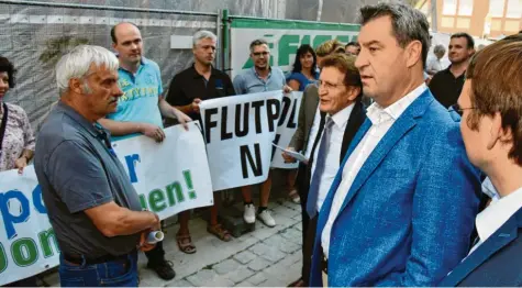  ?? Archivfoto: Karl Aumiller ?? Bei seinem Wahlkampfa­uftritt im Juli in Dillingen sprach Ministerpr­äsident Markus Söder auch mit Flutpolder-Gegnern des Bayerische­n Bauernverb­ands (links der Gremheimer Obmann Philipp Uhl). Söder sicherte eine fachliche Prüfung des Hochwasser­schutz-Konzepts zu. Im Koalitions­vertrag wurden jetzt andernorts Polder-Standorte gestrichen, nicht jedoch im Landkreis Dillingen.