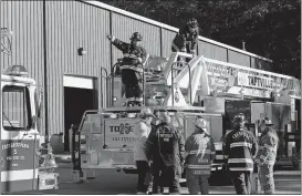  ?? DANA JENSEN/THE DAY ?? Firefighte­rs gather at the scene of a fire Thursday at Atlantic City Linen Supply at 5 Consumers Ave. in Norwich.