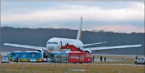  ?? RICHARD JUILLIART / AGENCE FRANCE-PRESSE ?? Police evacuate passengers on Monday from the Ethiopian Airlines flight en route to Rome, which was reportedly hijacked by the aircraft’s co-pilot and forced to land in Geneva, where the co-pilot was arrested, police said.