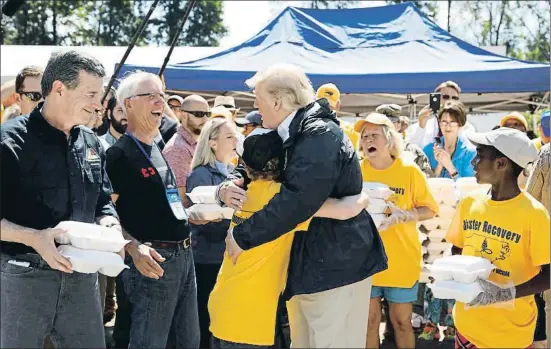 ?? KEVIN LAMARQUE / REUTERS ?? El president Trump abraça un noi en un centre de distribuci­ó de menjar als afectats pel Florence, a Carolina del Nord
