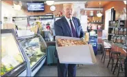  ?? EVAN VUCCI — THE ASSOCIATED PRESS ?? President Donald Trump holds a pizza during a visit to Arcaro and Genell restaurant after speaking at a campaign event in Old Forge.